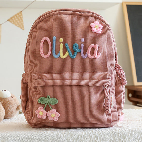Dusty rose backpack with a colourful knitted name