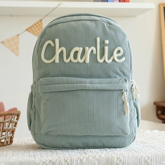 Sage green backpack with a knitted name
